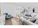 Open-concept living space with a comfortable gray sofa and view of the entry and staircase at 5848 Sheffield Ln, Whitestown, IN 46075