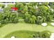 An aerial shot showcases a charming home surrounded by mature trees next to a meticulously manicured golf course at 6115 E 65Th Pl, Indianapolis, IN 46220