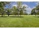 Lush green lawn extending towards a fence line, with mature trees and golf course visible beyond at 6115 E 65Th Pl, Indianapolis, IN 46220