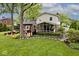 Beautiful backyard with a spacious lawn, wooden deck, hot tub, screened-in porch, and lush landscaping at 6115 E 65Th Pl, Indianapolis, IN 46220