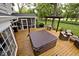 A backyard deck features a hot tub, grill, pergola, and screened-in porch, ideal for relaxation and outdoor gatherings at 6115 E 65Th Pl, Indianapolis, IN 46220
