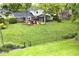 Expansive backyard featuring a large lawn, wooden deck, and mature trees, perfect for outdoor activities at 6115 E 65Th Pl, Indianapolis, IN 46220