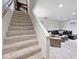 Finished basement with carpeted stairs leading to a cozy seating area and a leather sofa at 6115 E 65Th Pl, Indianapolis, IN 46220