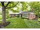 Charming two-story home featuring a mix of brick and siding, complemented by mature trees and manicured landscaping at 6115 E 65Th Pl, Indianapolis, IN 46220