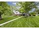 Charming two-story home featuring a mix of brick and siding, complemented by mature trees and manicured landscaping at 6115 E 65Th Pl, Indianapolis, IN 46220