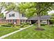 Charming two-story home featuring a mix of brick and siding, complemented by mature trees and manicured landscaping at 6115 E 65Th Pl, Indianapolis, IN 46220