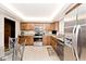 Kitchen with stainless steel appliances, tile floors, and wooden cabinetry at 6115 E 65Th Pl, Indianapolis, IN 46220