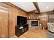 Living room featuring a brick fireplace, wood paneling, and hardwood floors at 6115 E 65Th Pl, Indianapolis, IN 46220