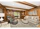 Living room with wood paneling, comfortable seating, and access to an outdoor space at 6115 E 65Th Pl, Indianapolis, IN 46220
