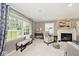 Elegant living room featuring a fireplace, plush seating, and large windows that flood the space with natural light at 6115 E 65Th Pl, Indianapolis, IN 46220