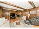 Comfortable living room with a brick fireplace, wood paneling, and neutral furniture at 6115 E 65Th Pl, Indianapolis, IN 46220