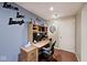 Bright office with a desk, overhead storage, and decor on the wall with the text 