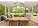 This large screened-in porch features brick flooring, a white wood ceiling, and outdoor furniture and views at 6115 E 65Th Pl, Indianapolis, IN 46220
