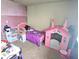 A bedroom featuring pink walls, a bed with a purple blanket, and play castle at 615 Albermarle Dr, Pittsboro, IN 46167