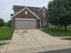 Traditional two-story brick home featuring an attached two-car garage and extended concrete driveway at 615 Albermarle Dr, Pittsboro, IN 46167