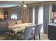 View of a living room table with seating, tile floors, and curtains leading to a sliding glass door at 615 Albermarle Dr, Pittsboro, IN 46167