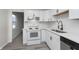 Well-lit kitchen featuring white cabinets, modern appliances, and wood-look flooring at 625 E 106Th St, Carmel, IN 46280