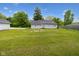View of a large manicured backyard with mature trees and a detached gray garage at 6450 N State Road 75, North Salem, IN 46165