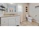 Bathroom features a white basin vanity, granite countertop, a toilet, a decorative mirror, and a window at 6450 N State Road 75, North Salem, IN 46165
