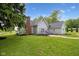 View of the exterior features a brick chimney, a cozy deck with seating, and green grass at 6450 N State Road 75, North Salem, IN 46165