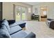 A modern living room features natural light, a comfortable blue sofa, and an open doorway to the Primary bedroom at 6450 N State Road 75, North Salem, IN 46165