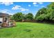 Expansive green backyard with a well-maintained lawn, mature trees, and a wooden fence for added privacy at 7312 Drum Castle Ct, Indianapolis, IN 46259