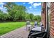 Cozy deck with seating and grill overlooking a lush, green backyard with mature trees and a privacy fence at 7312 Drum Castle Ct, Indianapolis, IN 46259