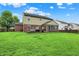 View of the home's exterior with a spacious, well-manicured backyard and a cozy deck for outdoor enjoyment at 7312 Drum Castle Ct, Indianapolis, IN 46259