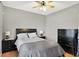 This bedroom features a ceiling fan, hardwood floors, a dresser, and nightstands with lamps at 7312 Drum Castle Ct, Indianapolis, IN 46259