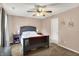 This bedroom features a ceiling fan, bed, nightstands, lamps, curtains, and plush carpeting at 7312 Drum Castle Ct, Indianapolis, IN 46259