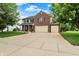 Beautiful two-story brick home with a three-car garage and wide driveway lined with lush landscaping at 7312 Drum Castle Ct, Indianapolis, IN 46259