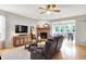 Cozy living room featuring a brick fireplace, ceiling fan, wood floors, and access to a dining area at 7312 Drum Castle Ct, Indianapolis, IN 46259