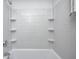 Bathroom featuring subway tile walls, a shower-tub combo, and built-in shelving at 7414 Mendenhall Rd, Camby, IN 46113