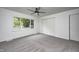 Neutral bedroom with light gray carpet, white walls, ceiling fan and a window overlooking the backyard at 7414 Mendenhall Rd, Camby, IN 46113