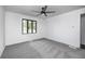 Neutral bedroom featuring light gray carpet, white walls, ceiling fan and a window overlooking the backyard at 7414 Mendenhall Rd, Camby, IN 46113