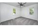 Bright bedroom featuring neutral carpeting, a ceiling fan, and two windows with outdoor views at 7414 Mendenhall Rd, Camby, IN 46113