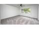 Bright bedroom featuring neutral carpeting, a ceiling fan, and a large window with a view of the outdoors at 7414 Mendenhall Rd, Camby, IN 46113