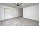 Neutral bedroom featuring light gray carpet, white walls, ceiling fan and double door closets at 7414 Mendenhall Rd, Camby, IN 46113