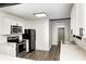 Well-lit kitchen with stainless steel appliances, white cabinets, contrasting black hardware, and sleek countertops at 7414 Mendenhall Rd, Camby, IN 46113