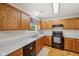 Cozy kitchen featuring wood cabinets, a black appliance suite and neutral countertops at 764 Port Dr, Avon, IN 46123