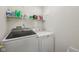 Laundry room with modern Samsung washing machine and a dryer, with shelving above at 764 Port Dr, Avon, IN 46123