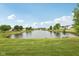 A beautiful view of the pond in the neighborhood, with a grassy bank and trees at 764 Port Dr, Avon, IN 46123