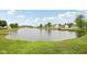 Scenic view of the neighborhood pond surrounded by lush green grass and mature trees under a blue sky at 764 Port Dr, Avon, IN 46123