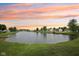 Scenic view of the community pond at sunset, surrounded by lush green lawns and mature trees at 764 Port Dr, Avon, IN 46123