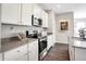 Modern kitchen features white cabinets, stainless appliances, gray countertops, and wood floors at 8856 Alexander Ridge Dr, McCordsville, IN 46055