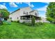 Back exterior view showcasing a spacious yard, covered patio, and traditional siding at 9001 Harrison Run Ct, Indianapolis, IN 46256