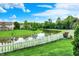 Expansive backyard featuring a picturesque pond, white picket fence, and well-maintained lawn at 9001 Harrison Run Ct, Indianapolis, IN 46256
