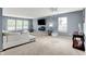 Spacious living room featuring large windows, neutral carpeting, and a stylish chandelier at 9001 Harrison Run Ct, Indianapolis, IN 46256