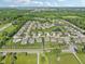 Overhead view of a residential area featuring landscaped yards, a community pond, and tree-lined streets at 9656 Summerton Dr, Fishers, IN 46037