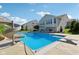 Backyard pool featuring a slide and diving board surrounded by lush landscaping and patio furniture at 9656 Summerton Dr, Fishers, IN 46037